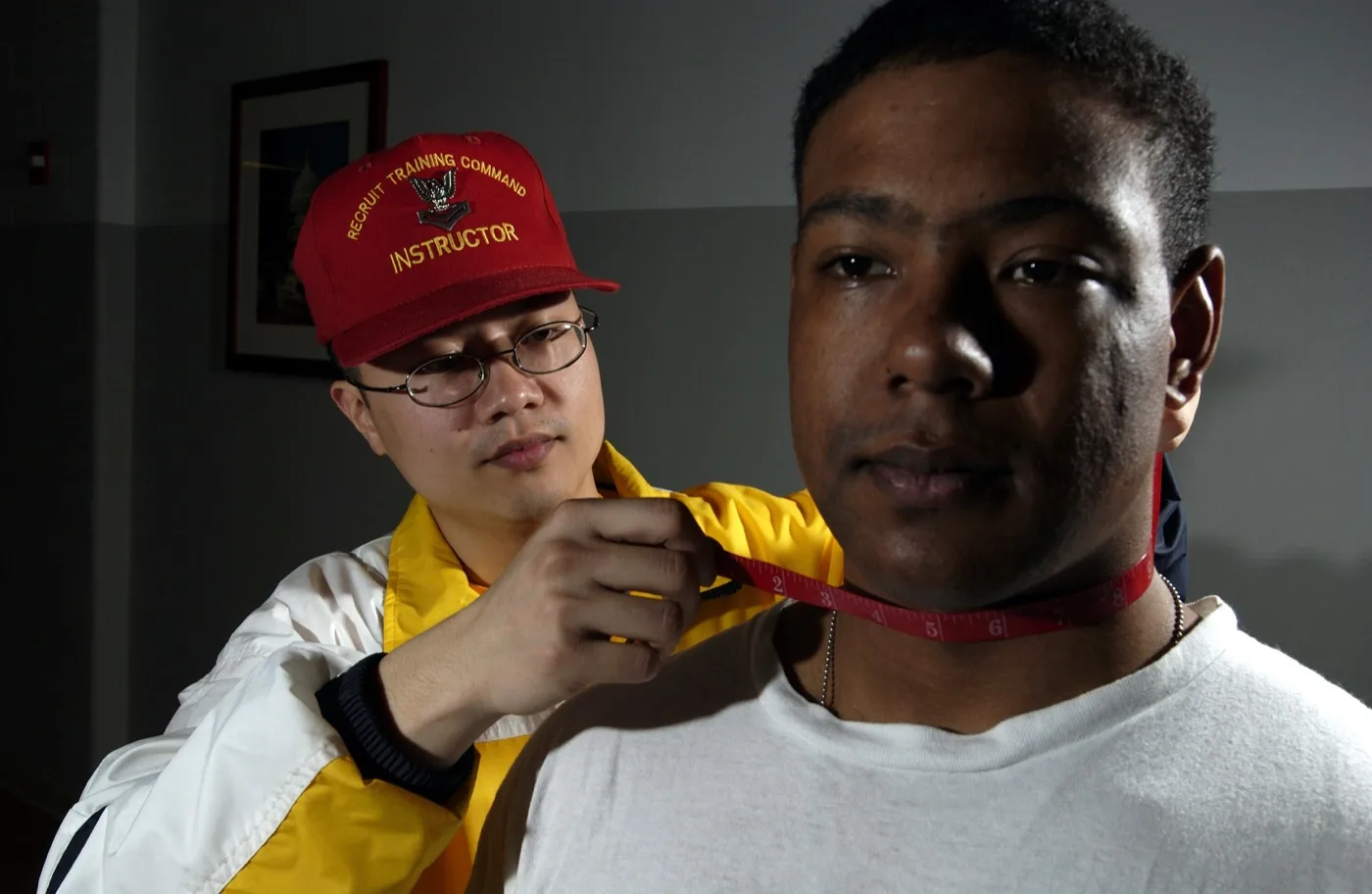 A body fat measurement being taken by a second person, using the tape method